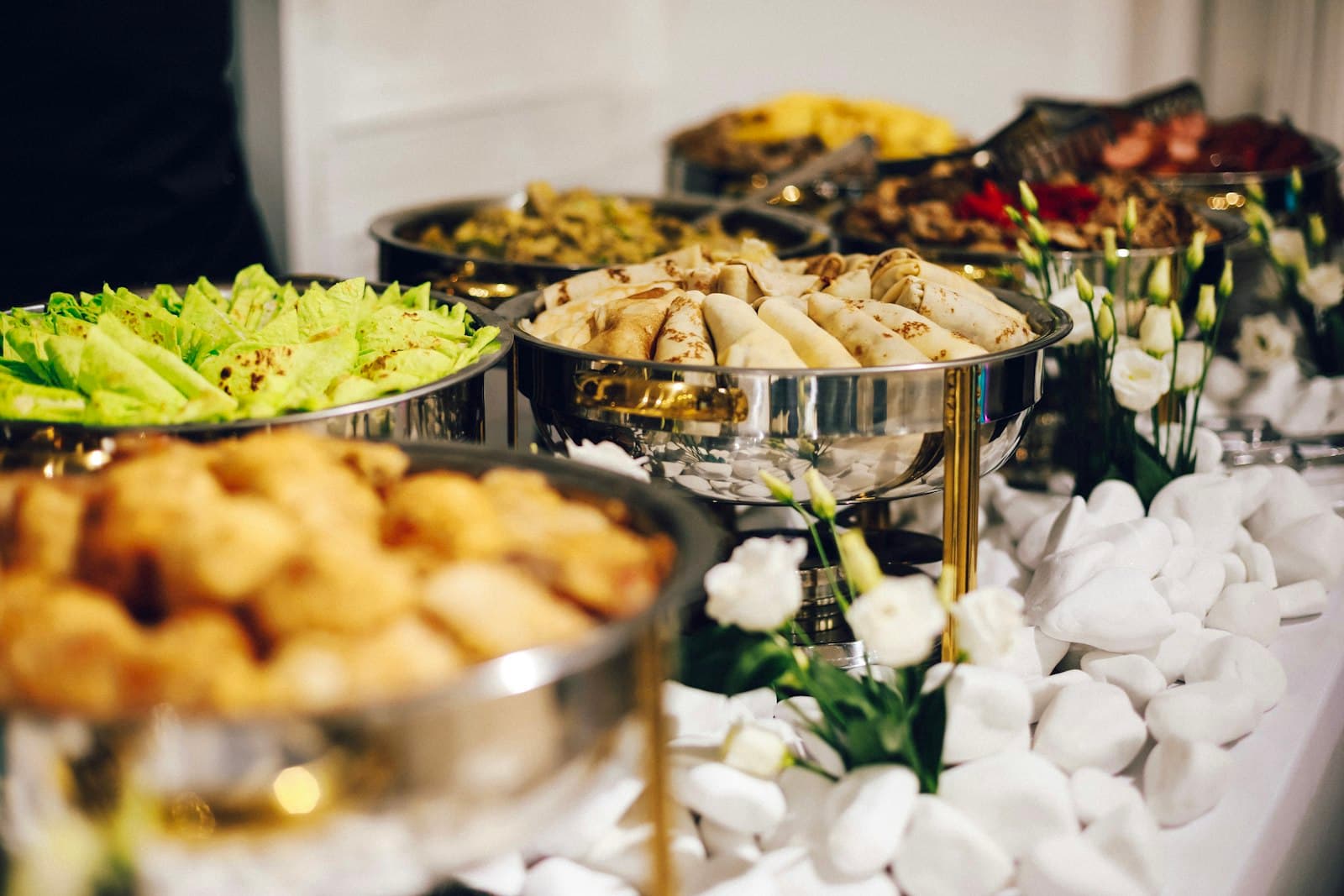 Mesa de buffet com réchauds e pratos servidos